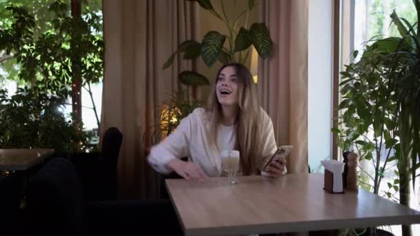 Две Молодые Женщины Встречаются Кофейне Улыбаясь Радуясь Друзья Обнимаются Кафе — стоковое видео