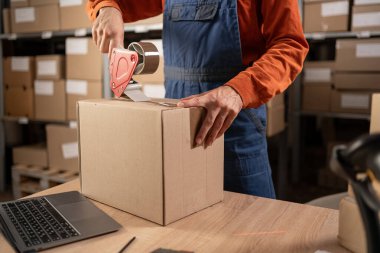 Perakende Deposundaki işçiler paket kutusuyla kasetçalarla nakliye için çalışıyorlar. Teslimat ve dağıtım merkezi raflarla dolu. Yakın plan. Boşluğu kopyala