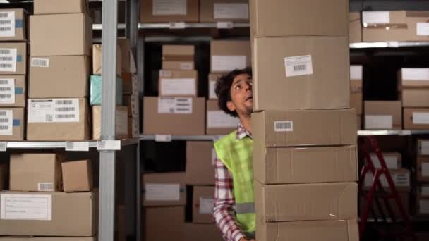 仓库工作人员提着一个纸箱运往生产库存 阿拉伯工作人员拿着反光背心扔了一堆箱子 工作场所的人 复制空间 — 图库视频影像