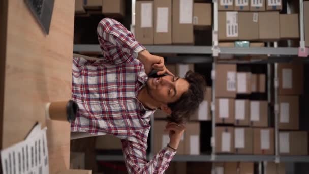 Empresário Árabe Feliz Falando Telefone Enquanto Trabalhava Laptop Seu Armazém — Vídeo de Stock