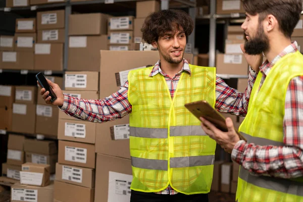 Two Multiethnic Warehouse Workers Discussing While Standing Shelves Boxes Copy — Stock Photo, Image