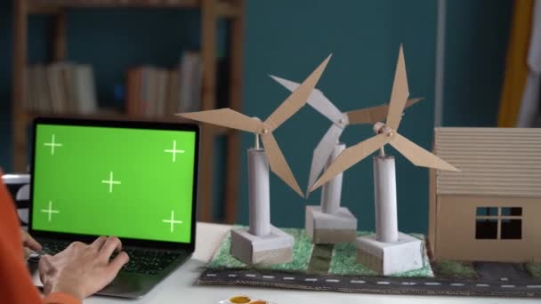 紙プロジェクトをコントロールし ラップトップコンピュータを使用して風車を維持する女性エンジニア 代替エネルギーと再生可能エネルギーの生産の概念 コピースペース — ストック動画