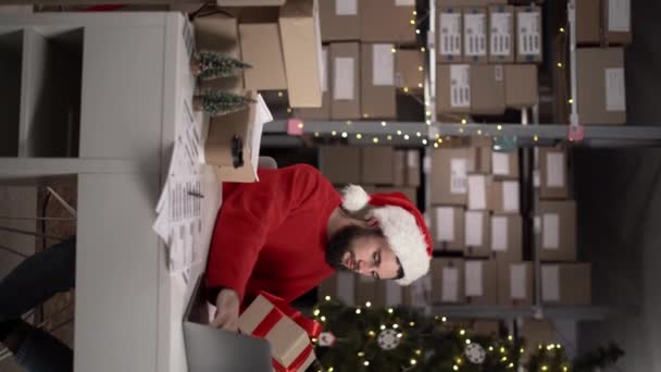 クリスマスイブの小売店で働く従業員 中小企業所有者はコンピュータで働く配達か郵送物のための小包を準備し 詰めます バーティカルビデオ — ストック動画
