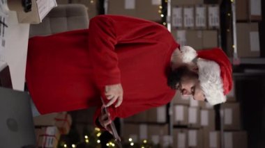 Genç İspanyol sakallı iş adamı Noel 'de çalışan bir depoda dokunmatik ped kullanıyor. Boşluğu kopyala