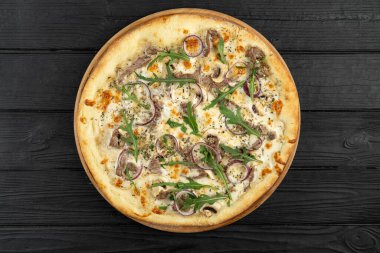 Dana etli pizza, kırmızı soğan ve ahşap arka planda roka, üst manzara, menü için düz manzara. Boşluğu kopyala