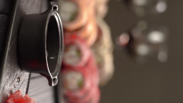 醤油に浸したチョップスティックでウナギとエビを巻いた寿司ロール バーティカルビデオ — ストック動画