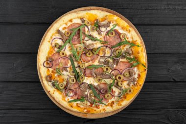 İtalyan fast food. Jambonlu sıcak pizza, et, soğan, ahşap arka planda zeytin, yakın görüş. Menü fotoğrafı. Üst Manzara. Düz yatıyordu