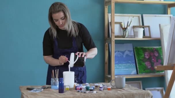기술에 그림을 그리기위한 아크릴 페인트를 앞치마에있는 예술가 — 비디오