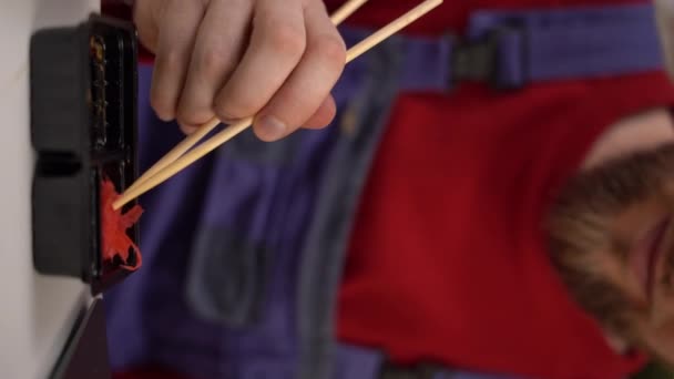 大胡子的桑塔用生姜和芥末做的筷子吃烤寿司 在工作场所吃午饭 提供寿司的概念 后续行动 — 图库视频影像