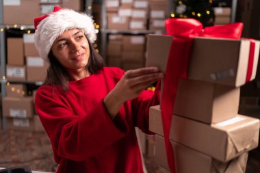 Karton paketlerle çalışan kadın envanter yöneticisi. Müşteri emirleri. Paketler dolusu mal sevkiyata hazır. Boşluğu kopyala