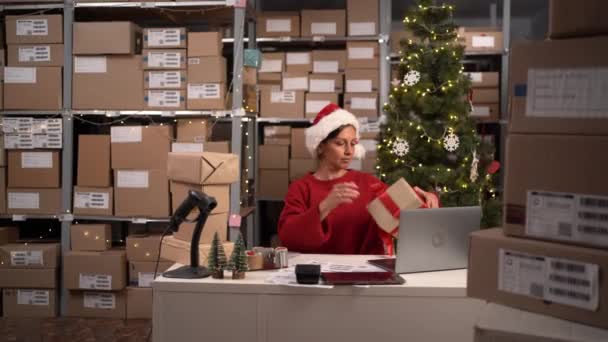 クリスマスの倉庫で忙しい日 小売店のストーリーロームで働く従業員 小規模なビジネスオーナーは ラップトップコンピュータで作業し 配達のための小包を準備します コピースペース — ストック動画