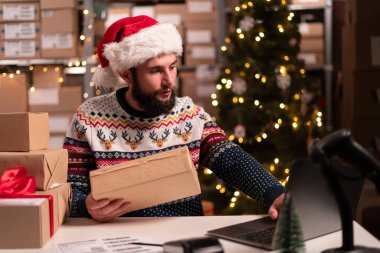Depo çalışanı müşteriler için Noel hediyesi paketleri hazırlıyor. Yeni yıl kutlaması, uzak çalışma, konsept. Boşluğu kopyala