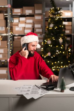 Dizüstü bilgisayarın önündeki mutlu adam depodaki online veri teslimatındaki telefon alım siparişlerini alıyor. Küçük bir iş kuralım. Noel indirimi. Boşluğu kopyala