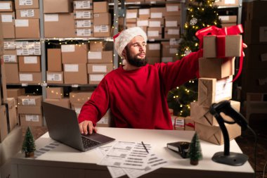 Noel Baba şapkalı sakallı adam bir depoda kırmızı kurdeleli Noel hediyeleri hazırlıyor. Masada karton kutular var ve işadamı eşyalarını topluyor. Yeni yıl indirimi kavramı