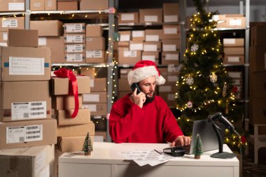 Dizüstü bilgisayarın önündeki mutlu adam depodaki online veri teslimatındaki telefon alım siparişlerini alıyor. Küçük bir iş kuralım. Noel indirimi. Boşluğu kopyala