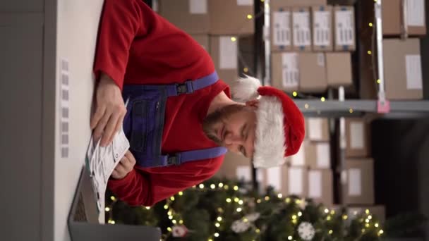 在线库存管理员使用笔记本电脑 准备邮包在储藏室工作 圣诞节大甩卖垂直录像 — 图库视频影像