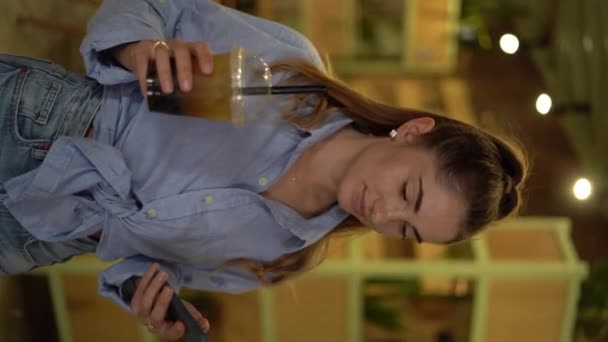 一个年轻的女人 带着一杯泡泡茶在咖啡店里散步 带着外卖的鸡尾酒 垂直录像 — 图库视频影像