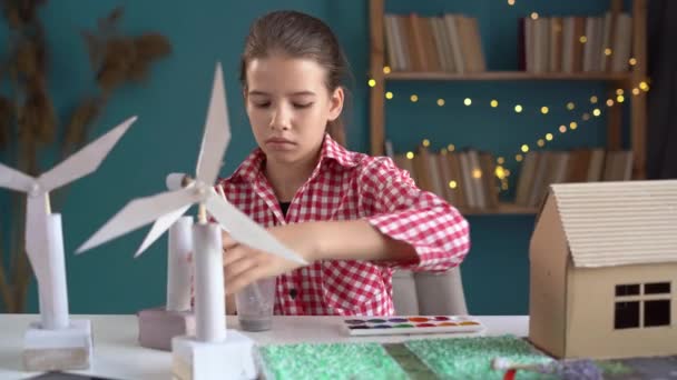 エコロジー テクノロジー 省エネのコンセプト かわいい女の子は自宅で風力タービンとエコフレンドリーな家の3Dモデルのプロジェクトを作成します コピースペース — ストック動画