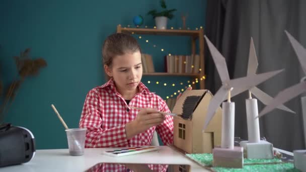 自宅で風力タービンの3Dモデルを持つ女子生徒は 学校のための再生可能エネルギープロジェクトを準備しています 再生可能エネルギー テクノロジー 人々のコンセプト — ストック動画