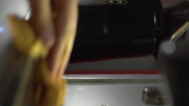 Restoranda ya da kafede çalışan yetenekli bir barista profesyonel kahve makinesini temizliyor, bez havlu kullanıyor, yakın plan. Dikey video