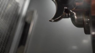 Kahve makinesi taze kahve hazırlıyor ve restoranda bardan ya da bardan yemek yemek için kağıt bardaklara dökülüyor. Yakın plan. Dikey video