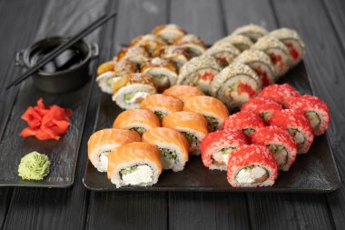 Suşi siyah taş tabakta. Çeşitli ekmekler. Japon yemeği. Suşi takımı konsepti. Menü. Üst Manzara. Boşluğu kopyala