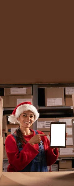 圣诞节前夕 女性库存经理手持空白白色屏幕的数字平板电脑 在仓库里有文字工作的空间 垂直横幅 — 图库照片