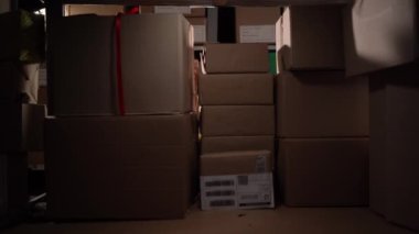 Eski bir depo işçisi diğer paketlerin olduğu bir rafta karton kutu arıyor. Depoda panosu olan envanter müdürü. Boşluğu kopyala