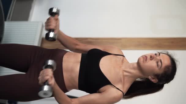 两名积极强壮的女运动员在运动服锻炼举重哑铃为健身俱乐部的胳膊和健康护理 垂直录像 — 图库视频影像