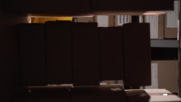 仓库的老工人收集纸板箱和架子上的包裹 放在推车上装运 垂直录像 — 图库视频影像