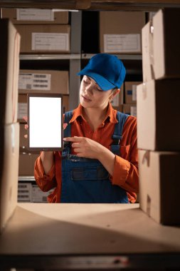 Depo müdürü dijital tablet kullanıyor, envanter çıkarıyor, maket ekran gösteriyor, paket teslimatını kontrol ediyor. Dağıtım Merkezi çalışanı. Boşluğu kopyala