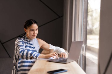Kafedeki dizüstü bilgisayarda yazan ve izleyen bir kız. Pencerenin yanındaki masada oturan genç konsantre blogcu. Serbest ve uzaktan kumandalı. Boşluğu kopyala