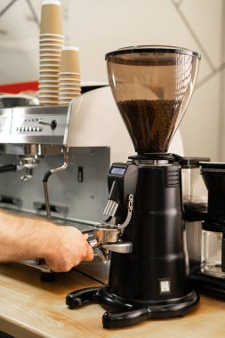 Makineli kahve öğütme işlemi, barista el ele tutuşması taze kavrulmuş kahve çekirdeği. Boşluğu kopyala