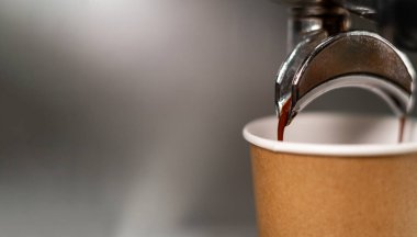 Otomatik kahve makineleriyle demlenen ve kağıt bardak kullanan kahve bardakları. Kağıttan yapılmış kahve kupaları. Uzayı kopyala Pankart.