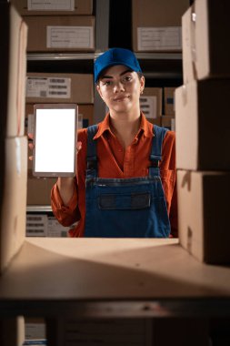 Kadın envanter müdürü elinde dijital tablet bilgisayarla boş bir kutu tutuyor. Boşluğu kopyala