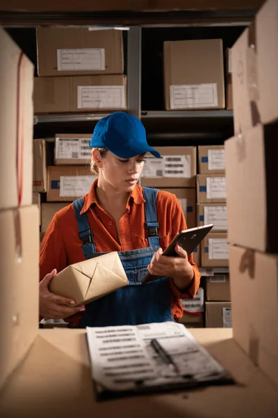 Female inventory manager using digital tablet working in warehouse storage. Copy space