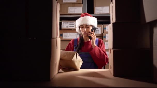 Менеджер Складу Санта Капелюсі Розмовляє Телефону Посміхаючись Тримаючи Посилку Відвантаження — стокове відео
