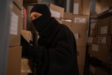 Hırsız gece depoda paket çalıyor. Boşluğu kopyala