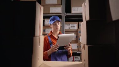 Depoda panosu olan bir depo çalışanı. Toptan, lojistik, insanlar ve ihracat konsepti