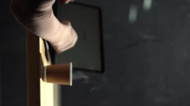 Kafede dizüstü bilgisayarı üzerinde çalışan bir kadının görüntüsü. Masasında buharlı kağıt kahve fincanı olan dizüstü bilgisayar kullanan bir kadın. Dikey video