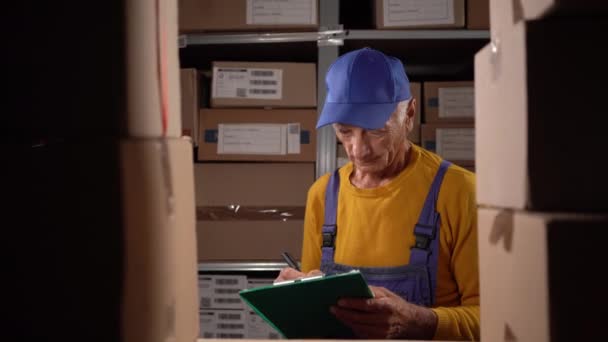 Oudere Mannelijke Magazijn Werknemer Met Behulp Van Klembord Controleren Van — Stockvideo
