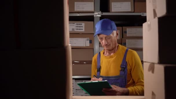 Пожилой Мужчина Менеджер Инвентаризации Проверяет Запас Пишет Бумагах Проблемы Старик — стоковое видео