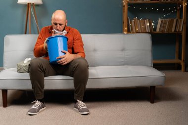 Beyaz bir adam hasta midesinden muzdarip ve evde kusuyor. Boşluğu kopyala