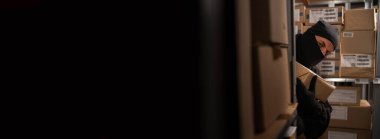 Siyah maskeli bir erkek hırsız gece depoda bir kutu mal çalıyor. Malların çalınması ve posta kutuları ile ilgili sorunlar. Uzayı kopyala Pankart
