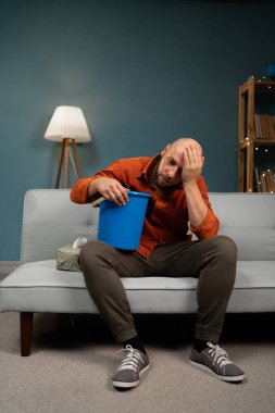 Yetişkin bir adamın midesi bulanıyor ve evde kusuyor. Hasta hissediyorum. Boşluğu kopyala