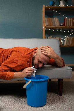 Evdeki kanepede kusan bir adam. Zehirlenme, zehirlenme ve mide bulantısı. Yakın plan.