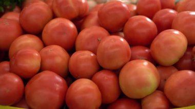 Bir kadın eli yemek rafından taze bir domates alır. Organik ürünler. Sebze ve meyve. Sağlıklı yiyecekler. Süpermarketten alışveriş.