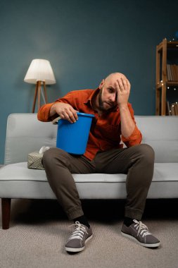 Yetişkin bir adamın midesi bulanıyor ve evde kusuyor. Hasta hissediyorum. Boşluğu kopyala