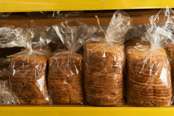 Свежий хлеб. Вкусные буханки хлеба в пластике в пекарне. Крупный план