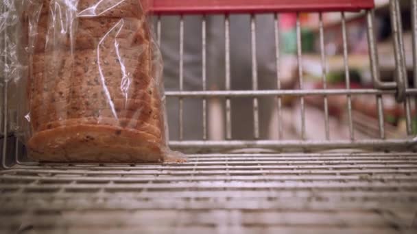 若い女性の手のクローズアップは トマトソースに豆をショッピングカートに入れる コピースペース — ストック動画